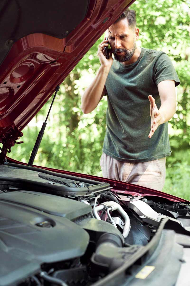 Junger Mann prüft Getriebeschaden bei Schrottauto Ankauf Salzgitter